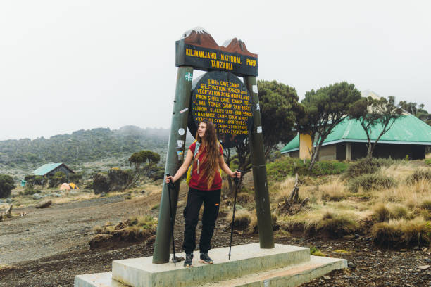 Smiling woman traveler with long hair resting after the hiking trip, staying at the campsite on Mount Kilimanjaro, Tanzania